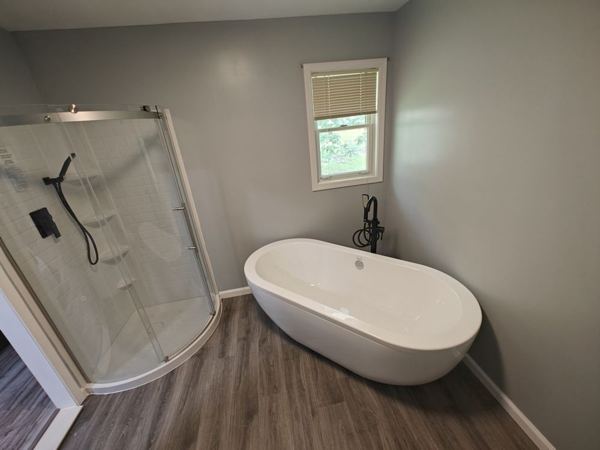 Bathroom with corner glass shower and freestanding soaking tub