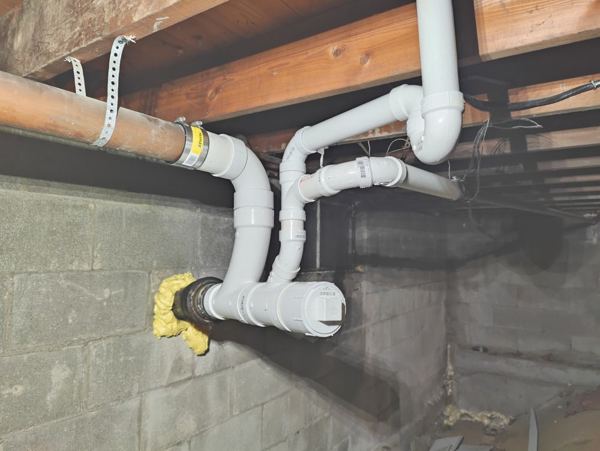 New PVC drain and vent line installed in a basement