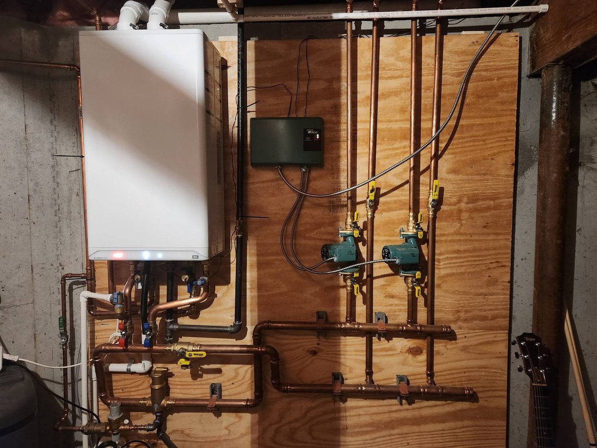 Wall-hung boiler with zone circulators and copper piping by Word Of Mouth Plumbing