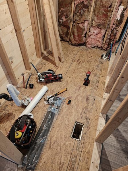 Drain lines run through an opened subfloor