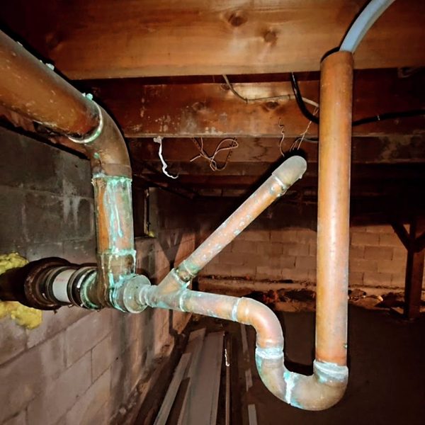 Copper supply and PVC drain piping in a basement ceiling