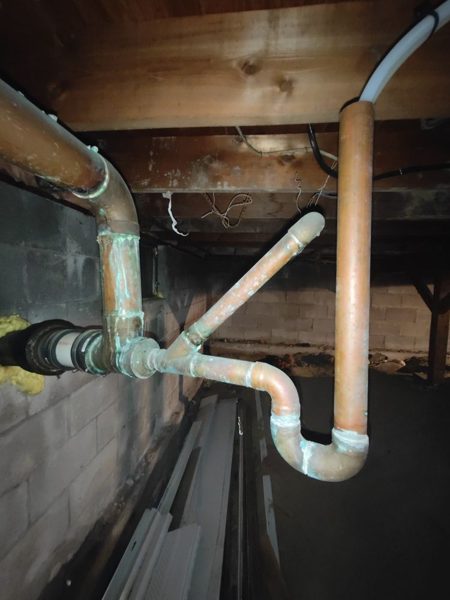 PVC drain line tied in under the floor joists