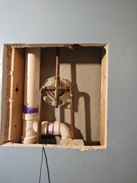Tub valve and drain behind a wall access panel